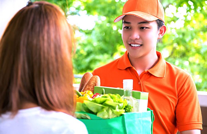 Delivery man delivering food to a woman at home